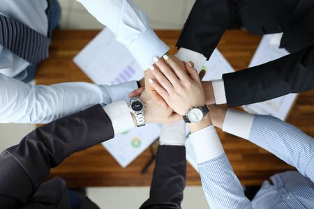Business success concept. Group people hold together hand close up top view background. Teamwork...