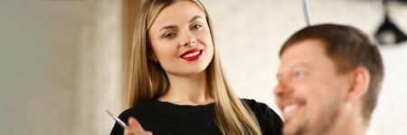 Blonde Hairdresser with Man Customer in Salon. Beautiful Hairstylist Holding Scissors in Hand....