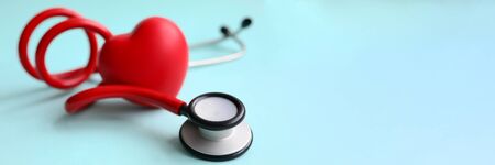 Red stethoscope with heart on blue modern background. Medical insurance concept