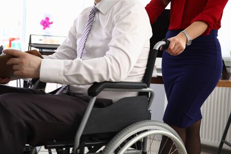 Woman carries man in suit on wheelchair workplace. Person moves on wheelchair. Interview invitation....