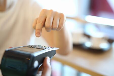 Man dials a PIN code at terminal, payment by card. Selection an effective acquiring offer. Payment...