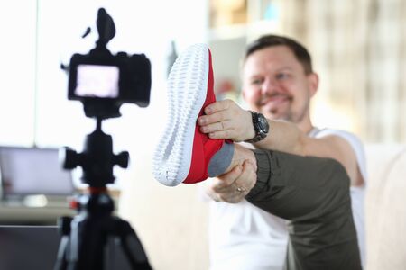 Man raised his leg and shows sneaker to camera. Video product review affects potential buyer. Description appearance sneakers. Video why this product is better than differs from others product marketの写真素材