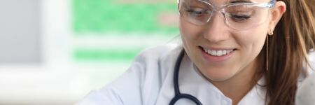 Portrait of woman in clinic office and performing examination of little patient with annoying illness. Child opening mouth wide and to help female doctor. Medicine and healthcare conceptの写真素材