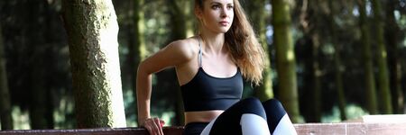 Portrait of wonderful woman pumping buttocks muscles. Beautiful sportswoman in fashionable sportswear looking away with concentration. Fitness and sport conceptの写真素材
