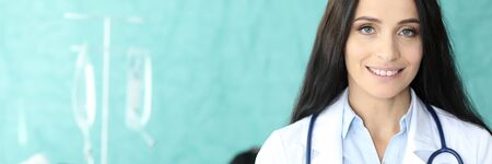 Portrait of lovely doctor holding paper folder. Cute lady writing appointment to sick patient. Dropper dripping to ill male. Healthcare and medicine conceptの写真素材