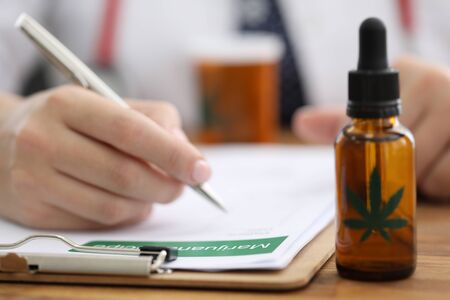 Closeup doctors hand writing prescription for hemp. Doctors prescribe cannabis for sleep disturbance. Hemp is part medication recommended for muscle spasms and epilepsy. Brain functioningの写真素材