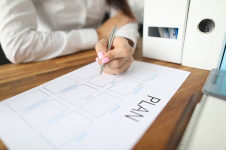 Woman draws up paper financial payment boards. Account grouping and cash flow analysis. Multilevel...