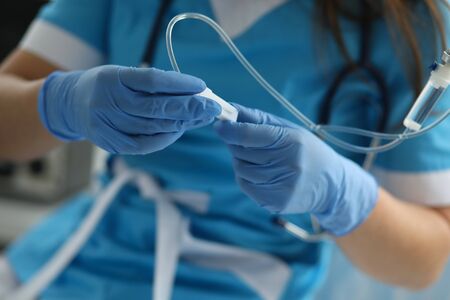 Close-up of medical worker with drop bottle and catheter. Professional female doctor in uniform at hospital. Diagnostic and clinic support. Healthcare and modern medicine conceptの写真素材