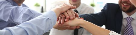 Group of businessman and businesswoman celebrating victory and teamspirit giving high five in air...