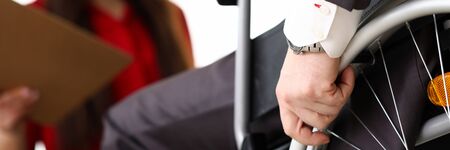 Man in suit on wheelchair communicates with woman. Prestigious job for people with disabilities. Office has working conditions for disabled. Active employment people with disabilitiesの写真素材