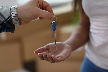 Man gives woman keys to apartment, rental property. Business closes premises during global quarantine. Closing offices during pandemic. Rent and purchase real estate. Moving to new apartmentの写真素材