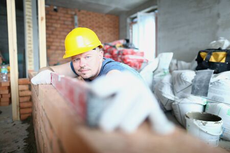 Professional foreman wearing protecting helmet while working at the facility with his team