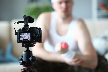 Silhouette of male person that sitting on sofa and demonstrating technique of lifting dumbbellsの写真素材
