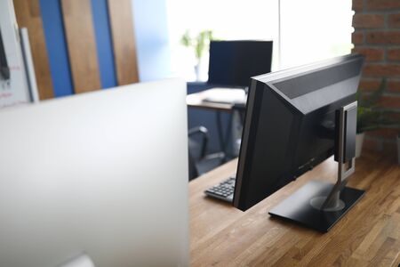Close-up of company office with modern computers on wooden table. Expensive device with sign. Stylish working place for people. Technology and development conceptの写真素材