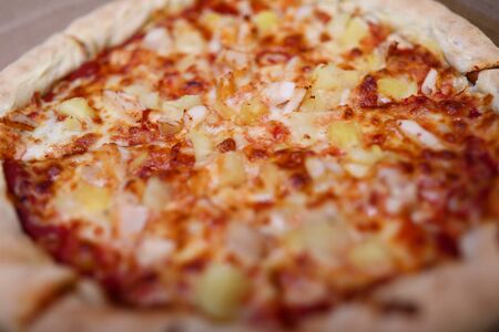 Close-up of small homemade round shaped pizza. Hot fresh yummy salami double cheese parmesan mozzarella and tomatoes. Traditional italian food. Fastfood and lunch conceptの写真素材
