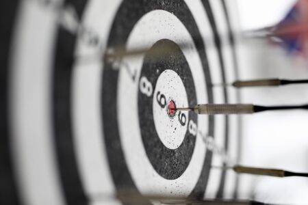 Close-up of darts board with arrows. Black and white circles with numbers for goal. Joyful and relax. Spare time for hobby. Play time and entertainment conceptの写真素材