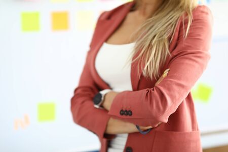 Close-up of stylish well-dressed woman posing with crossed arms. Blonde company worker in white shirt and pink jacket. Cropped picture of professional specialist. Modeling conceptの写真素材