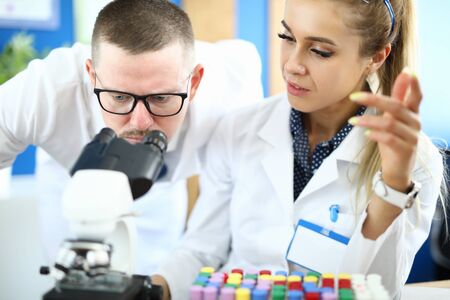 Two chemists on meet against chemistry lab background. Pharmaceutical educalion concept