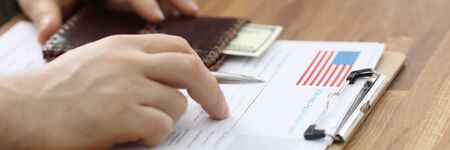 Male hands in suit lie on application for usa visa. Registration in the system embassies. Priority...