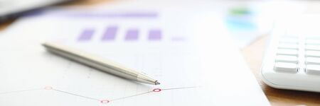 Table financial document with pen and calculator. Work with numbers and analysis statistical data....
