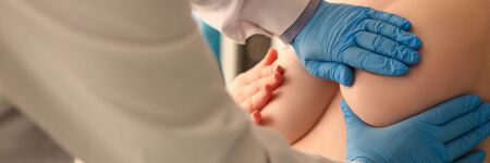 Close-up view of doctor mammologist examining breasts of patient in protective gloves. Prevention of disease. Planned checkup. Modern medicine and healthcare conceptの写真素材