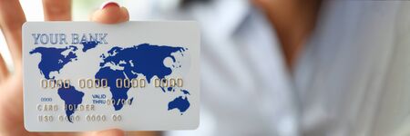 Woman arm holding banking card showing it to camera close-up