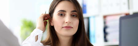 Portrait of pretty businesswoman sitting in office and looking at camera with gladness. Smart woman...