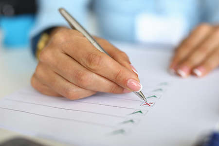 Woman fills out questionnaire by ticking document. Business development planning conceptの写真素材