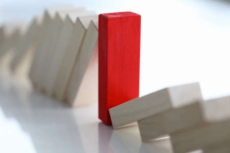 Close-up of red wooden stick standing on white desktop. Light cubes laying around. Leader and special one. Stand out of crowd. Uniqueness and leadership in life conceptの写真素材