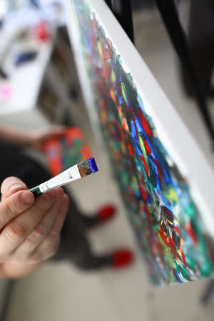 Close-up of persons hand creating abstract painting on canvas combine different styles. Picture with mixed colours. Creative and talented young male artist. Masterpiece and modern art conceptの写真素材