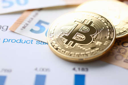 Top view close up of cryptocurrency above bank notes and financial chart on paperの写真素材