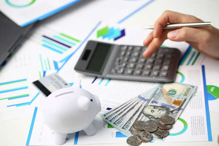 Close up top view of manager using calculator and papers for making economic balance in officeの写真素材