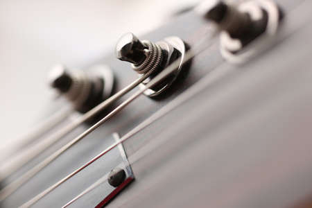 Close up of metal details on the guitar, strings are well tensed during playing the melodyの写真素材