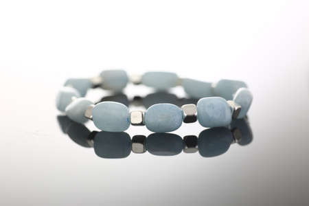 Focused photo on stylish jewelry that being reflected on glossy surface of the table