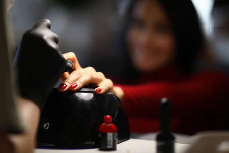 Happy woman in the salon does a manicure. Beautiful nails with a smooth coating and impeccable shape