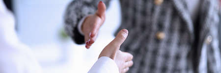Man and woman hold out their hands for handshake. Recommendations improving productivity. Remote...