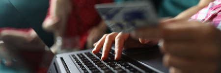 Female hand hold white plastic credit card closeup background. Distance telework conceptの写真素材