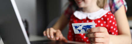 Happy child with mother hold plastic credit card in hand closeup against home background. Online shopping conceptの写真素材