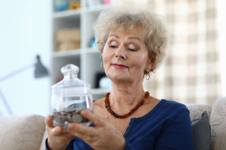Woman holds a piggy bank with coins. The accumulation of pension capital. Pay off all debts and...