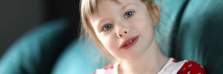 Little girl sitting at home sofa with piggy bank. Child with financial knowledge effectively manages...