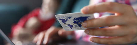 Woman sitting home sofa with laptop and credit card. Payment transportation costs. Repayment loans....
