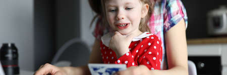 Woman sitting with baby at home in front laptop. Together with child to buy products together...