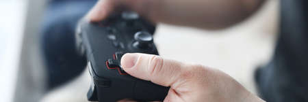 Two male friends play video games against home background. Gaming console concept
