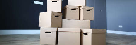 Interior an empty apartment, in center are boxes. Furniture packed in cardboard. Correctly packed items are reliably protected from various kinds damage during loading and during transportationの写真素材