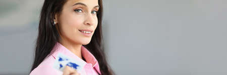 Close-up of smiling woman looking at camera with interest and gladness. Beautiful businesslady working in bank. Banking, business and e-payment company conceptの写真素材