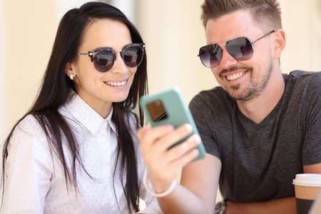 Adult modern fashion people look at smartphone screen portrait. Online social media surf concept