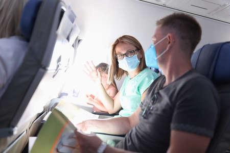Happy family tete on airplane sitting on diy on vacation portrait. Safe behavior during the COVID 19...