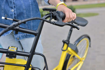 Bicyclist holds yellow Bicycle behind wheel. Bicycle rental and rental conceptの写真素材