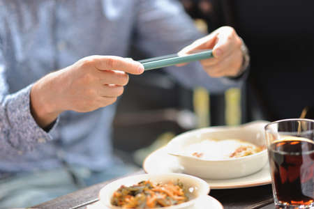 Cafe visitor photographs his lunch with smartphone. Food blogger review at bistro conceptの写真素材