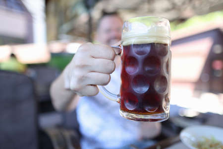 Man is holding glass of foamy glass with beer. Beer festivals conceptの写真素材
